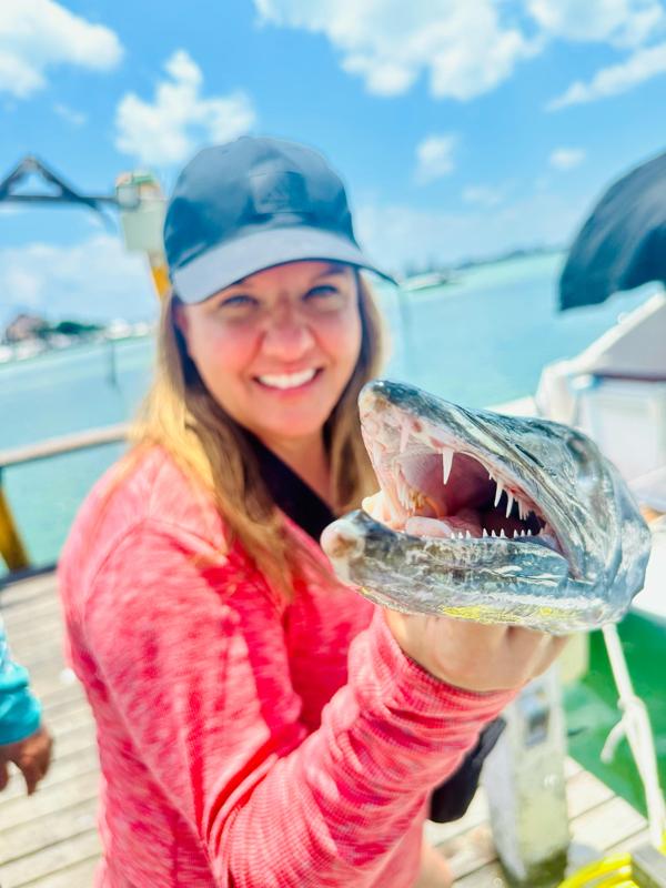 Smiling woman with a barracuda catch in Cancun
